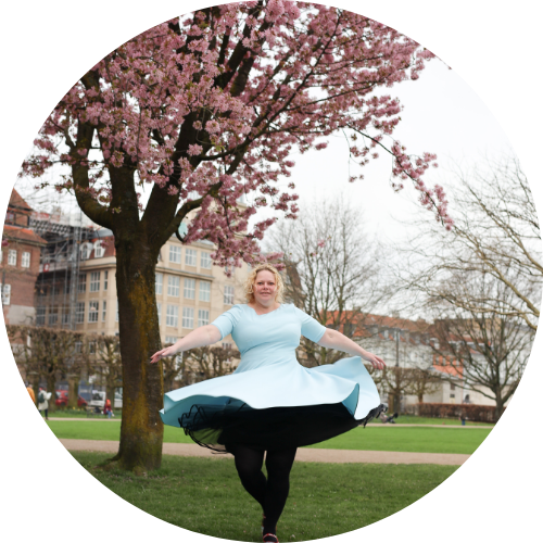 Nicoline Sidley under et kirsebærtræ i blomst