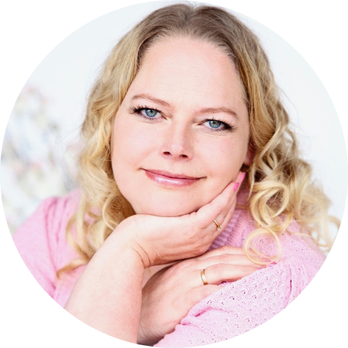 Rundt billede af Nicoline Sidley med blomster i baggrunden